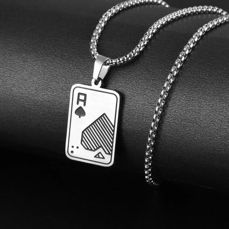 A silver-toned necklace with an Ace of Spades playing card pendant, displayed on a black textured surface.