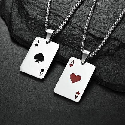 Two silver card-themed pendants on black stone background