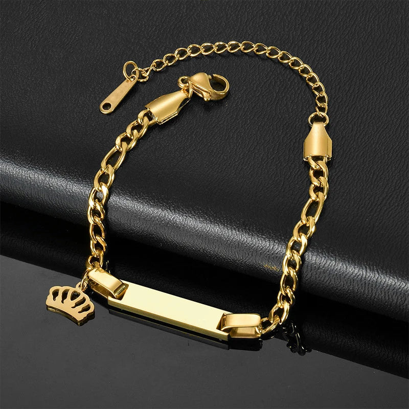 Baby bracelet featuring a crown charm and personalized nameplate.
