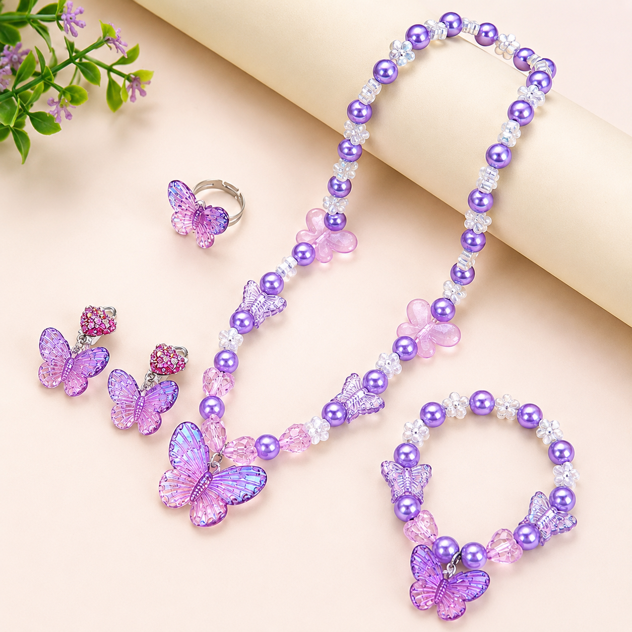 Complete butterfly jewellery gift set for girls featuring purple pearl necklace, bracelet, earrings and ring displayed on a decorative stone slab.