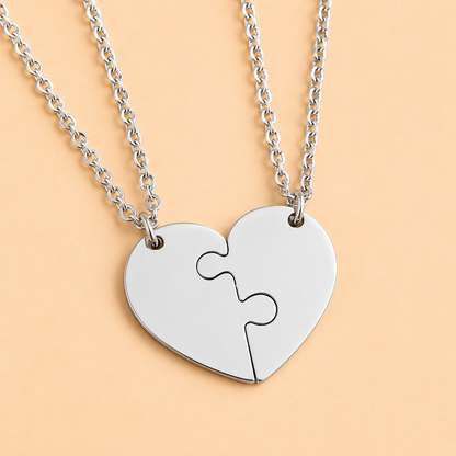 Close-up view of stainless steel heart puzzle pendants that fit together perfectly.