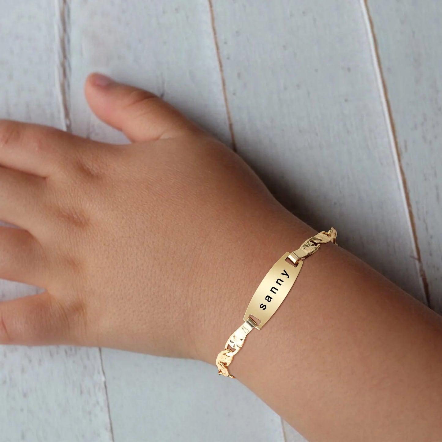 Personalized stainless steel baby bracelet engraved with a child's name.